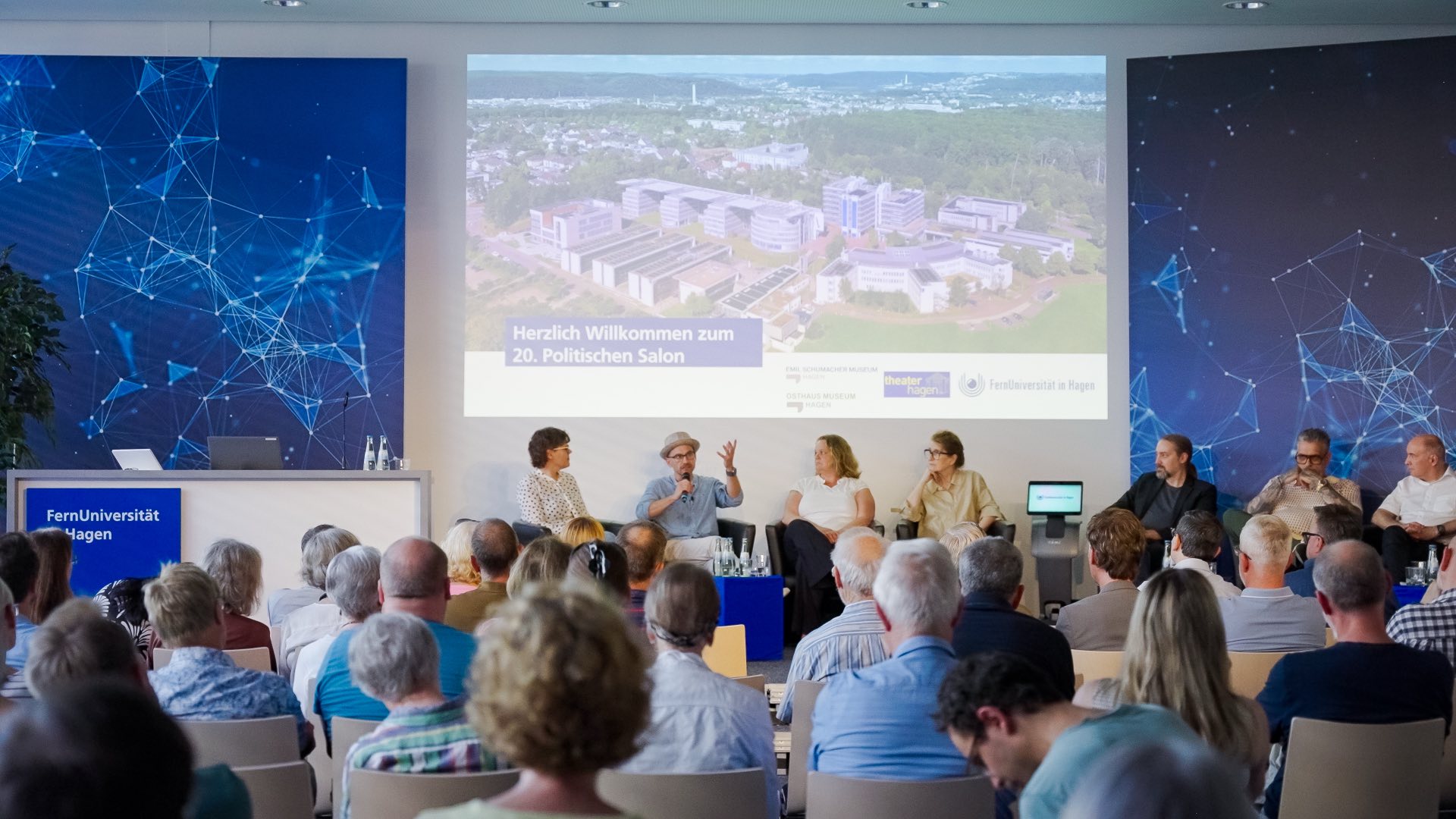 Marcel Colley auf dem Podium des 20. Politischen Salons der FernUniversität in Hagen, vor vollem Saal